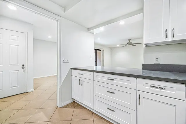 a kitchen with granite countertop white cabinets and white appliances