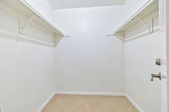 an empty room with a ceiling fan and a window