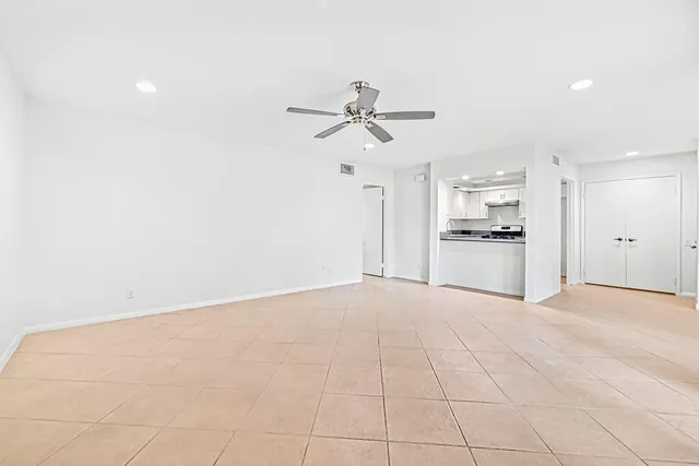 an empty room with windows and fan