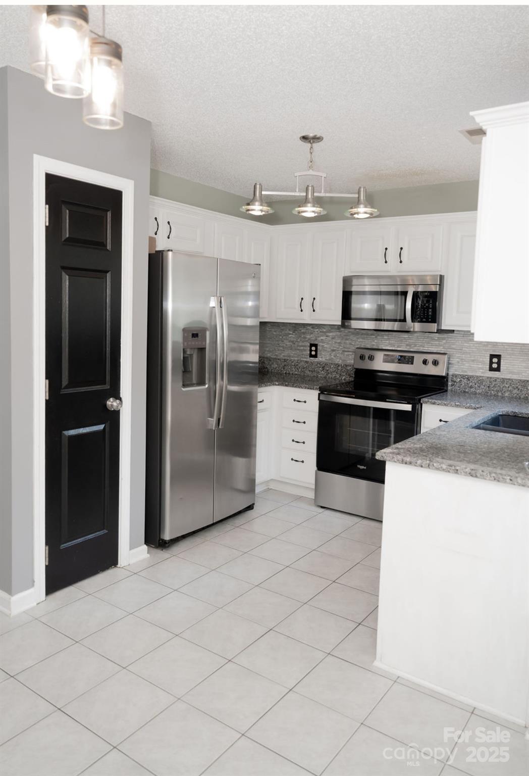 105 South Tanninger Road Mount Holly, NC 28120 - Photo 36 of 46 a kitchen with stainless steel appliances kitchen island granite countertop a refrigerator and a stove top oven