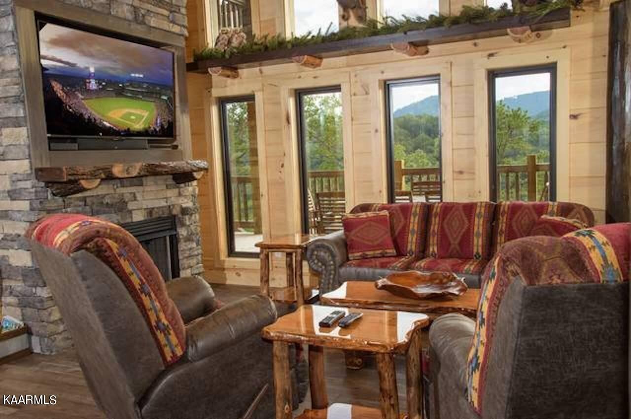 2252 Coopers Hawk Way Sevierville, TN 37862 - Photo 14 of 56 a living room with furniture a flat screen tv and floor to ceiling windows