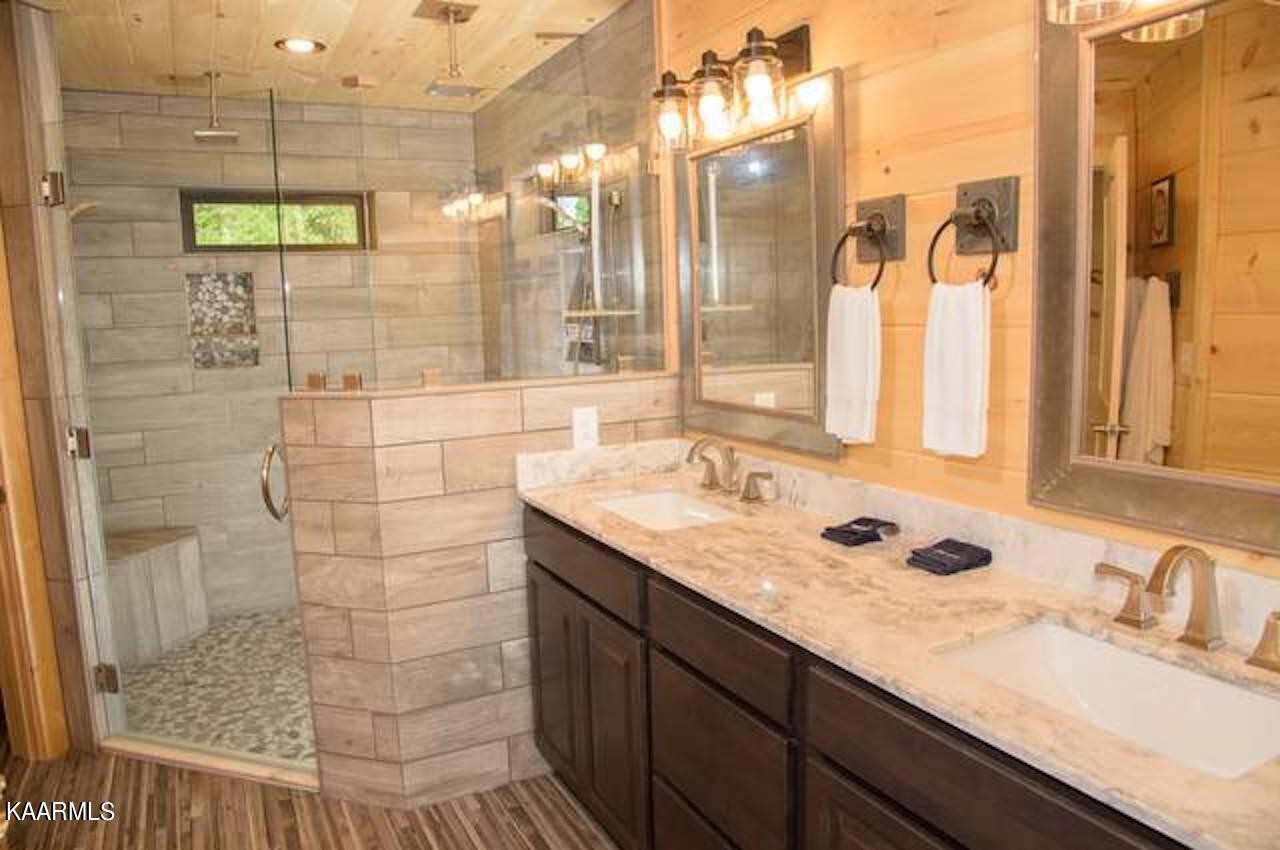 2252 Coopers Hawk Way Sevierville, TN 37862 - Photo 24 of 56 a bathroom with a granite countertop sink a mirror and shower