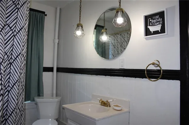 a bathroom with a toilet a sink and mirror