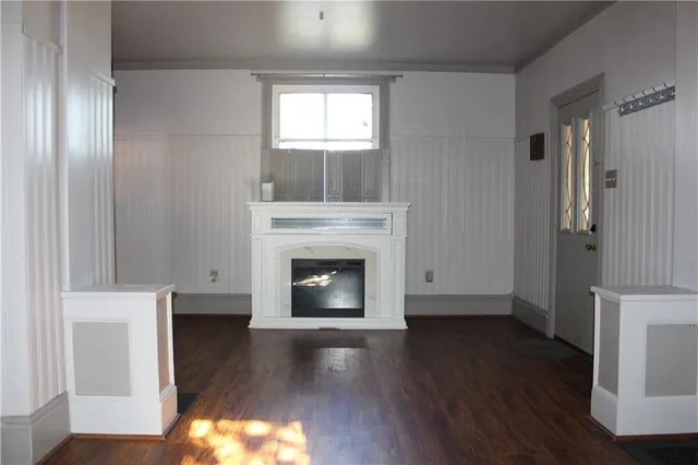 a view of a livingroom with a fireplace wooden floor and window