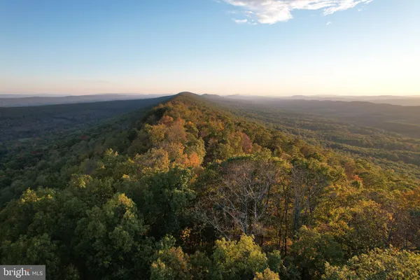 an aerial view of house with yard and mountain view in back