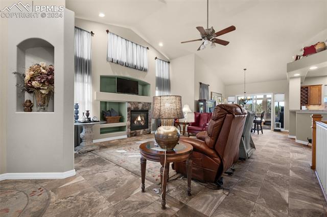 533 Talus Road Monument, CO 80132 - Photo 11 of 46 Living room with ceiling fan with notable chandelier and high vaulted ceiling