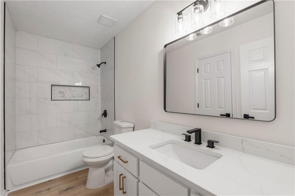 766 Lee Road Phenix City, AL 36870 - Photo 16 of 30 Bathroom featuring vanity, wood finished floors, and washtub / shower combination