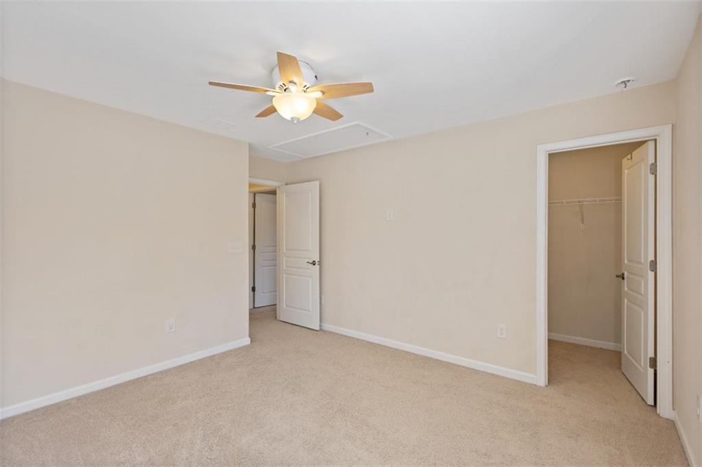 3500 Graham Way Southwest Lilburn, GA 30047 - Photo 27 of 47 an empty room with a chandelier fan and wooden floor