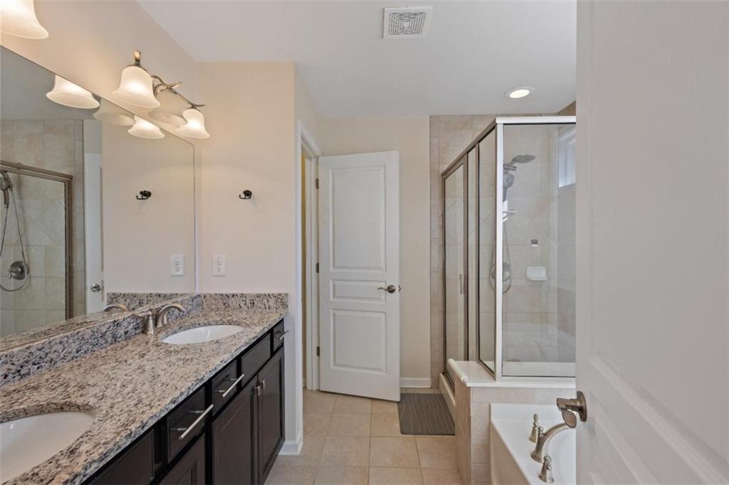 3500 Graham Way Southwest Lilburn, GA 30047 - Photo 36 of 47 a bathroom with a granite countertop sink a mirror and a bathtub