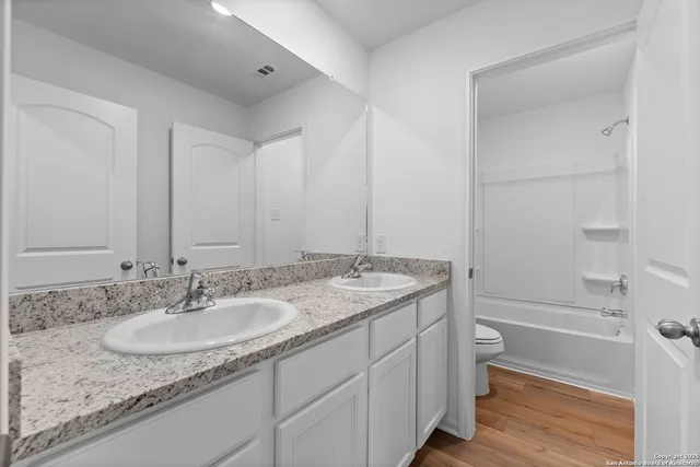 a bathroom with a granite countertop sink toilet and shower