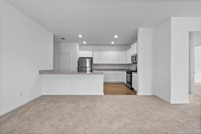 a view of kitchen with stainless steel appliances cabinets