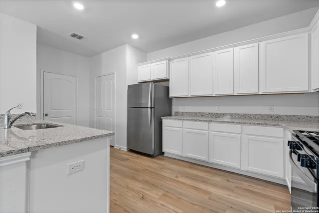 a kitchen with a sink a refrigerator and cabinets