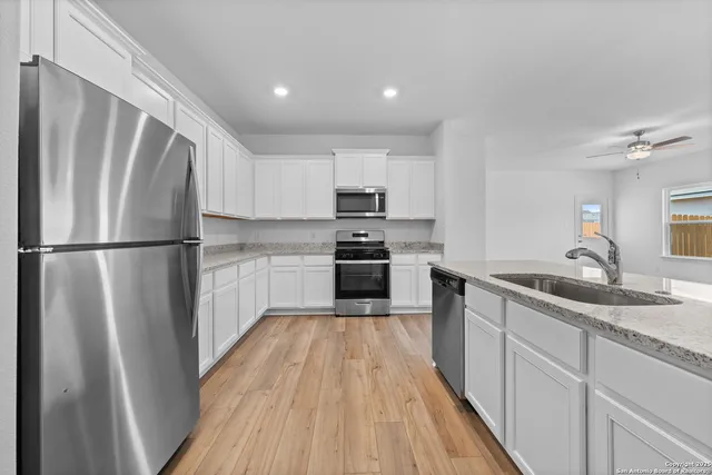 a kitchen with a refrigerator a sink and a stove top oven