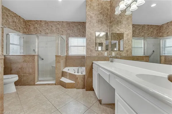 a spacious bathroom with a sink a toilet and a bathtub