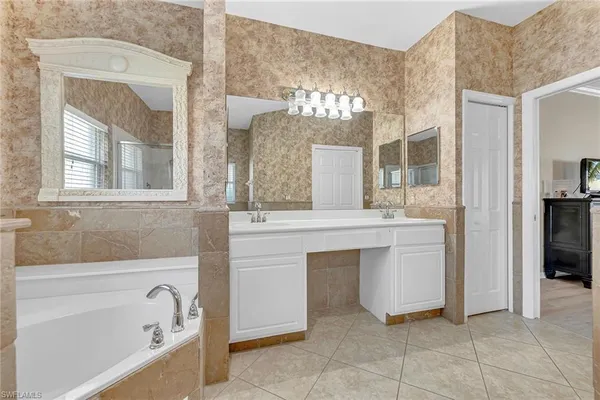 a bathroom with a tub sink and mirror