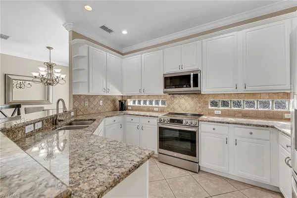 a kitchen with stainless steel appliances granite countertop a sink and stove top oven