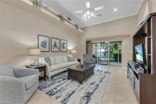 a living room with furniture flat screen tv and a large window