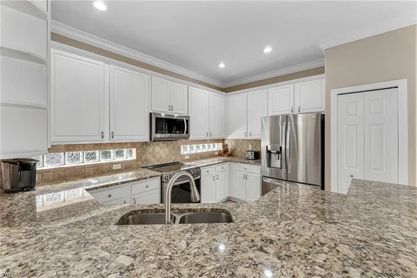 a kitchen with stainless steel appliances granite countertop a stove a sink and a refrigerator