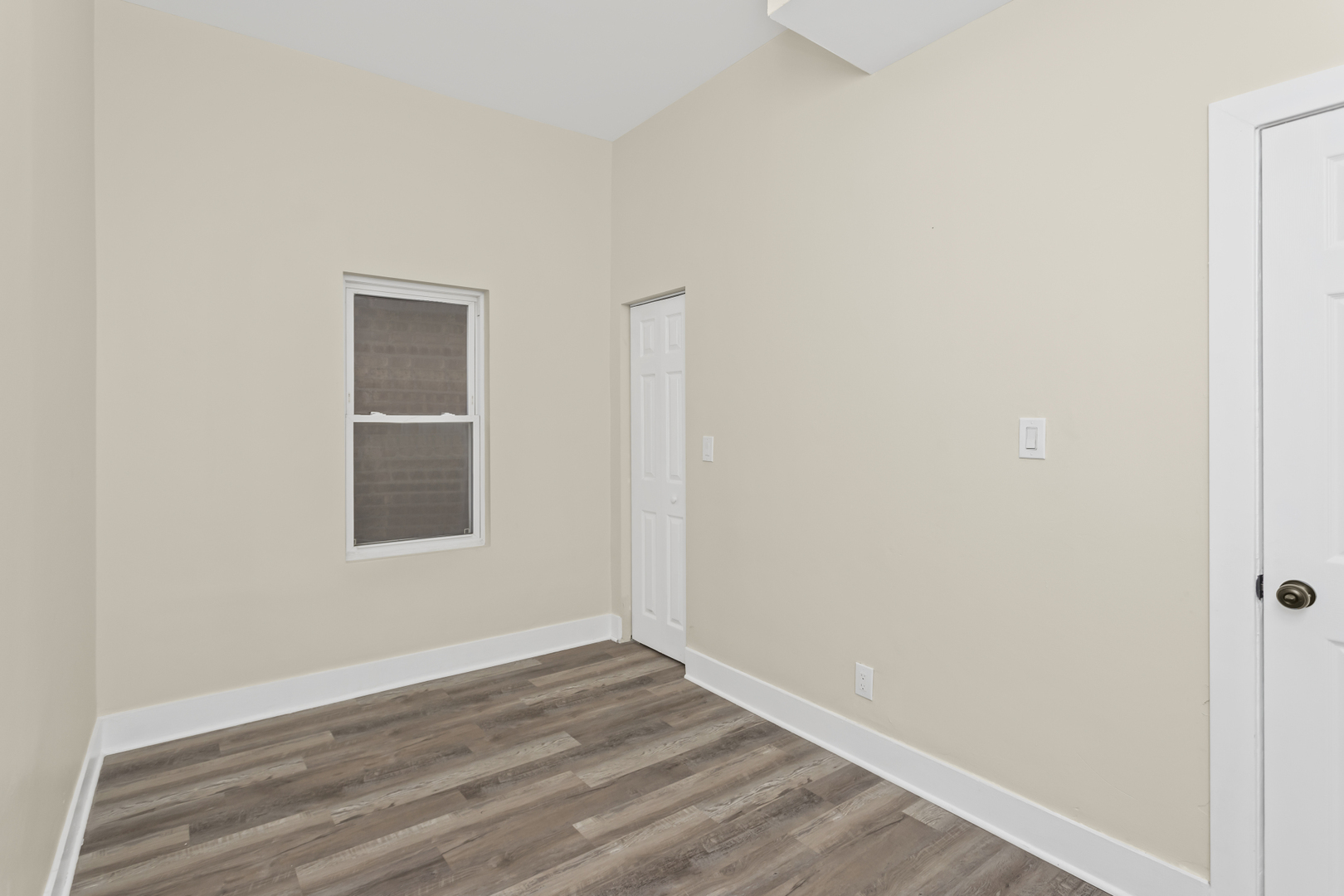 6601 South Rhodes Avenue Chicago, IL 60637 - Photo 17 of 22 a view of an empty room with wooden floor and a window