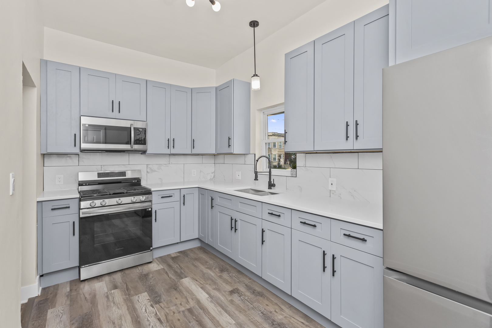 6601 South Rhodes Avenue Chicago, IL 60637 - Photo 20 of 22 a kitchen with white cabinets sink and stainless steel appliances