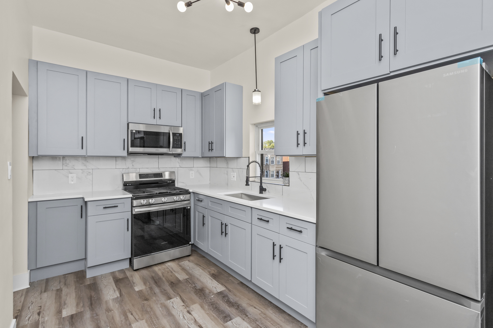 6601 South Rhodes Avenue Chicago, IL 60637 - Photo 10 of 22 a kitchen with stainless steel appliances granite countertop white cabinets a sink a stove a refrigerator and white cabinets