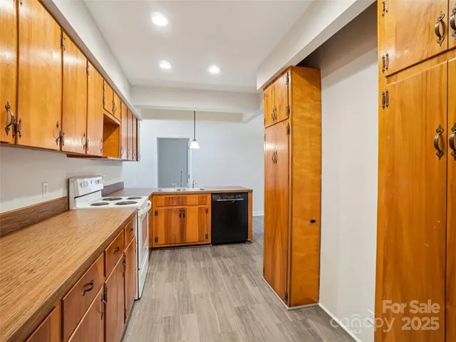 a kitchen with a refrigerator a sink and wooden cabinets