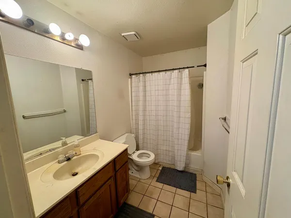 a bathroom with a sink a toilet a mirror and shower