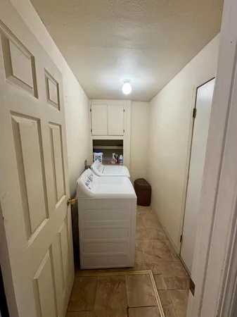a utility room with cabinets washer and dryer
