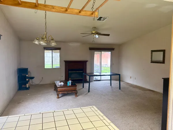 a living room with furniture a fireplace and a chandelier
