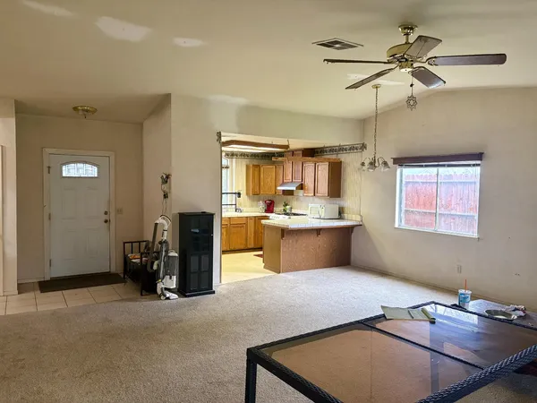 a room with table chairs and wooden cabinets