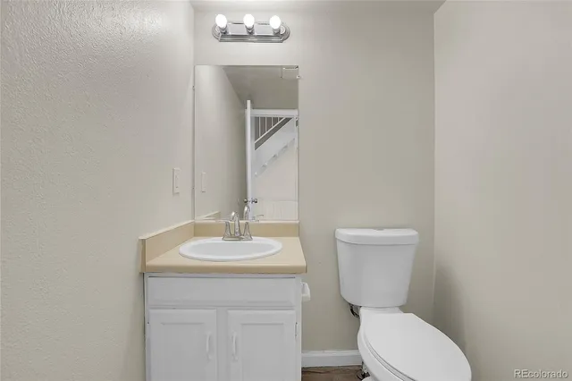 a bathroom with a toilet a sink and mirror