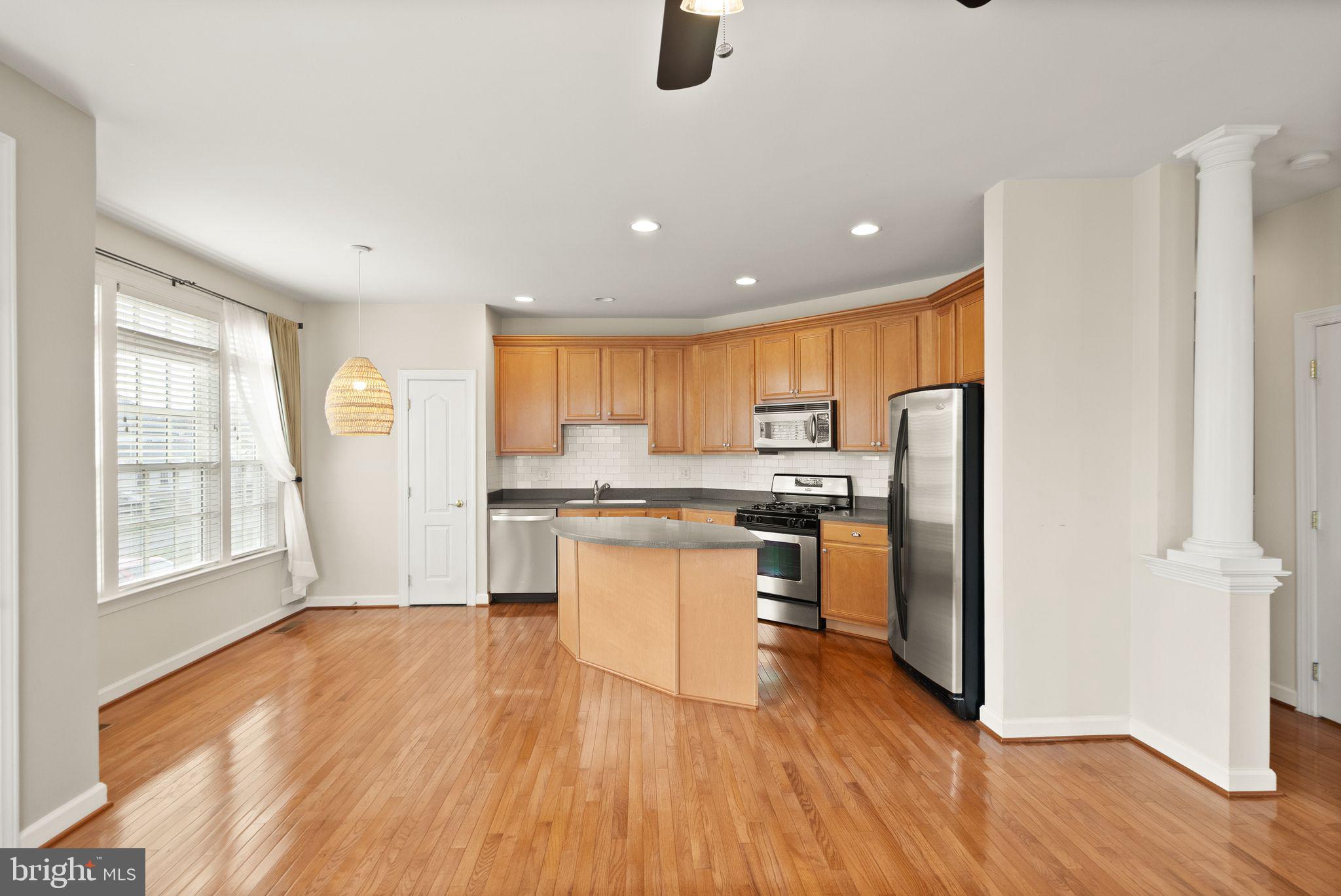 11821 Whitworth Cannon Lane Bristow, VA 20136 - Photo 24 of 70 a kitchen with stainless steel appliances granite countertop a refrigerator a sink a stove and oven with wooden floor