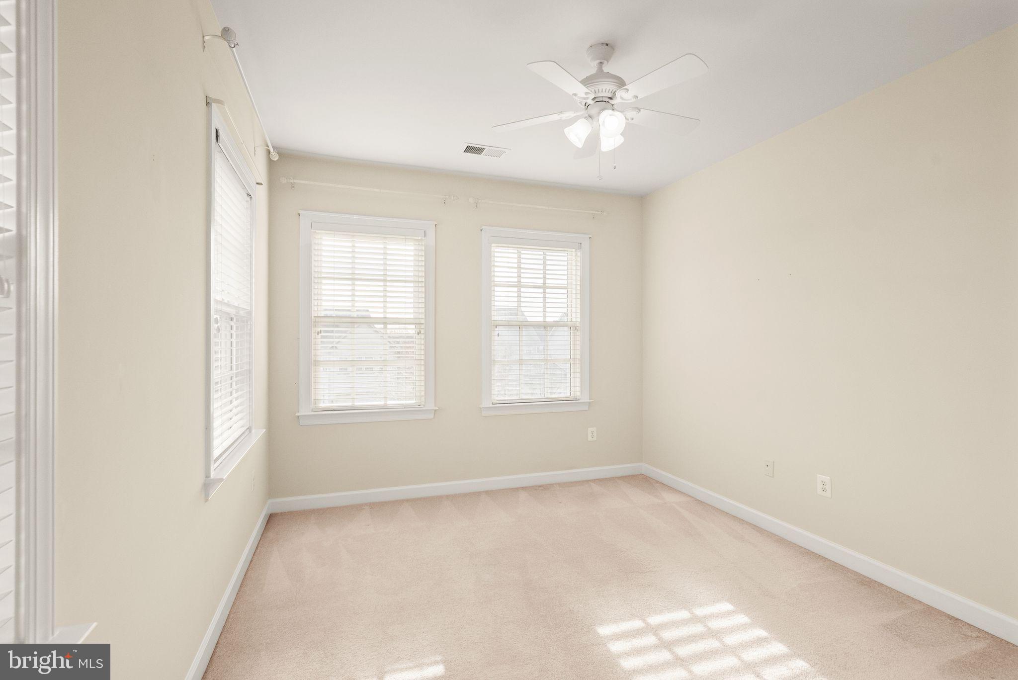 11821 Whitworth Cannon Lane Bristow, VA 20136 - Photo 47 of 70 an empty room with windows and ceiling fan