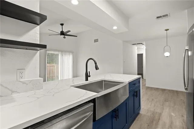 an empty room with wooden floor and ceiling fan