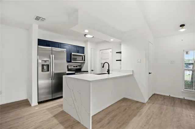 a view of a livingroom with wooden floor and a ceiling fan