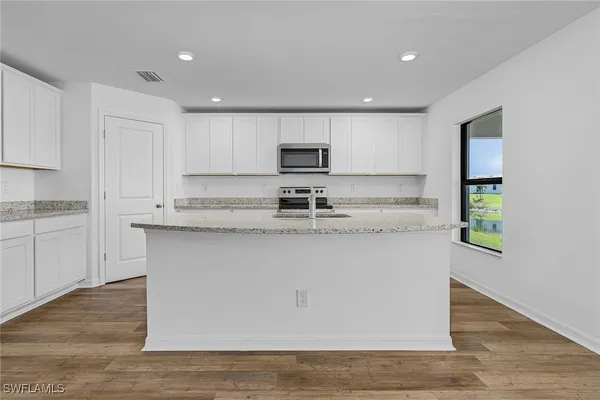 a kitchen with granite countertop a sink and cabinets