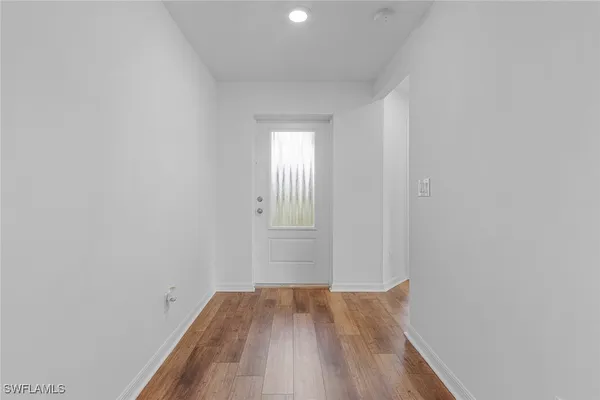 a view of a room with wooden floor and white walls