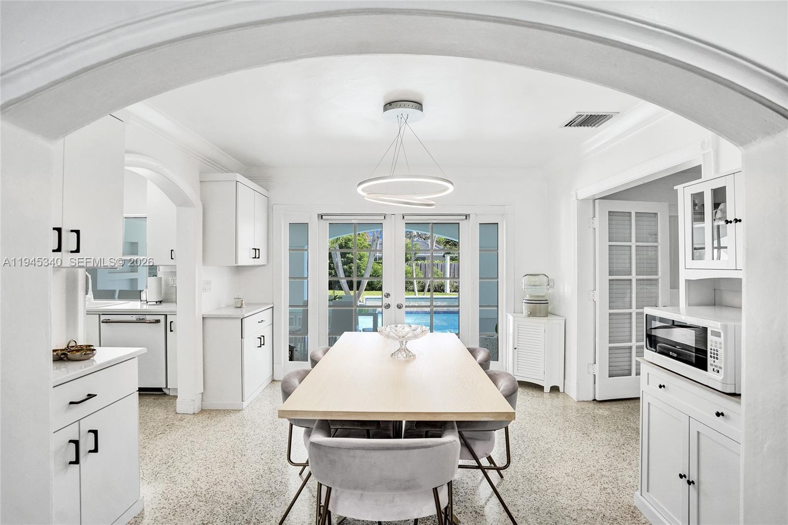 280 Northeast Spanish Court, Unit 280 Boca Raton, FL 33432 - Photo 5 of 41 a kitchen with a refrigerator a stove a sink dishwasher a dining table and chairs with wooden floor