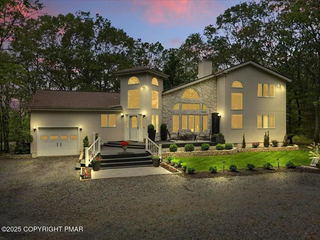 a living room with furniture a fireplace and a floor to ceiling window
