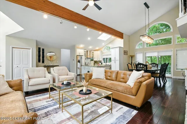 a kitchen with stainless steel appliances granite countertop a refrigerator a sink dishwasher a stove and white cabinets with wooden floor