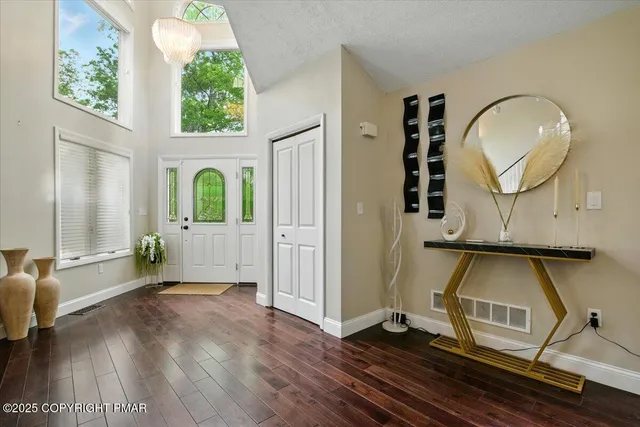 a living room with furniture a flat screen tv and floor to ceiling window