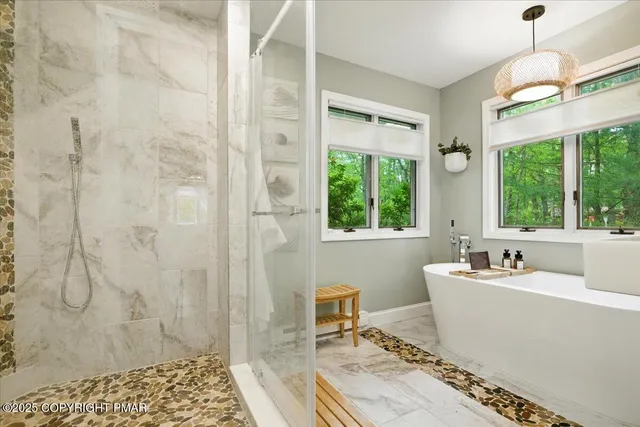 an aerial view of residential house with outdoor space and trees all around