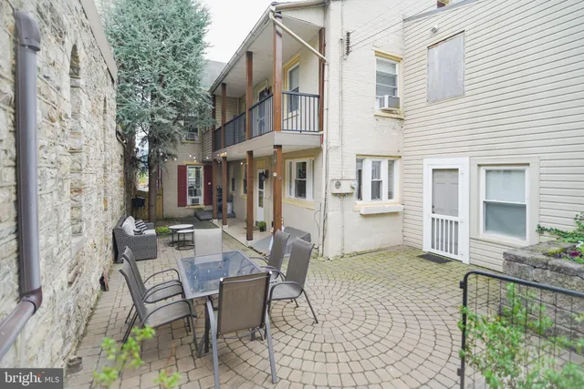 a view of a porch with chairs and potted plants