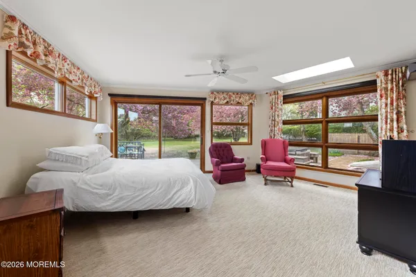 a bedroom with bed and large windows