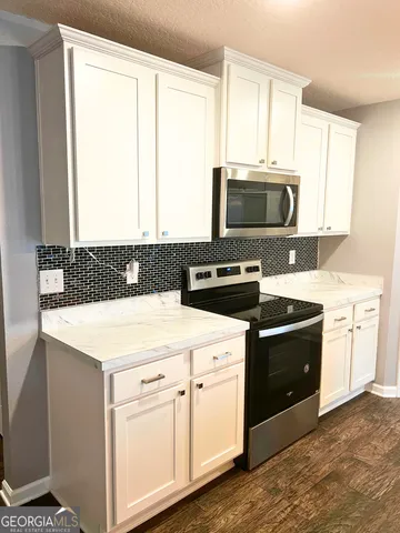 a kitchen with stainless steel appliances granite countertop a sink and a stove