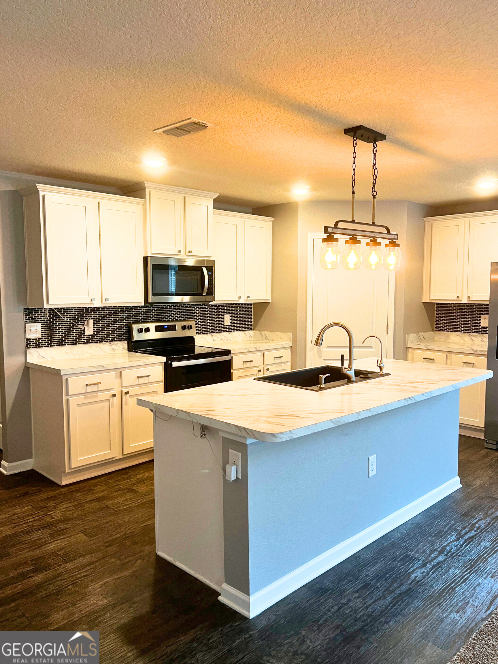129 Holston Circle Kingsland, GA 31548 - Photo 16 of 25 a kitchen with kitchen island granite countertop a sink cabinets and wooden floor