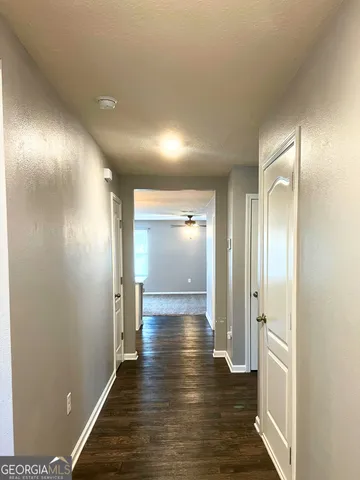 a view of a hallway with wooden floor