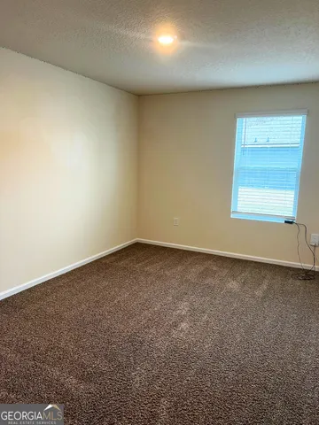 a view of a room with wooden floor and white walls