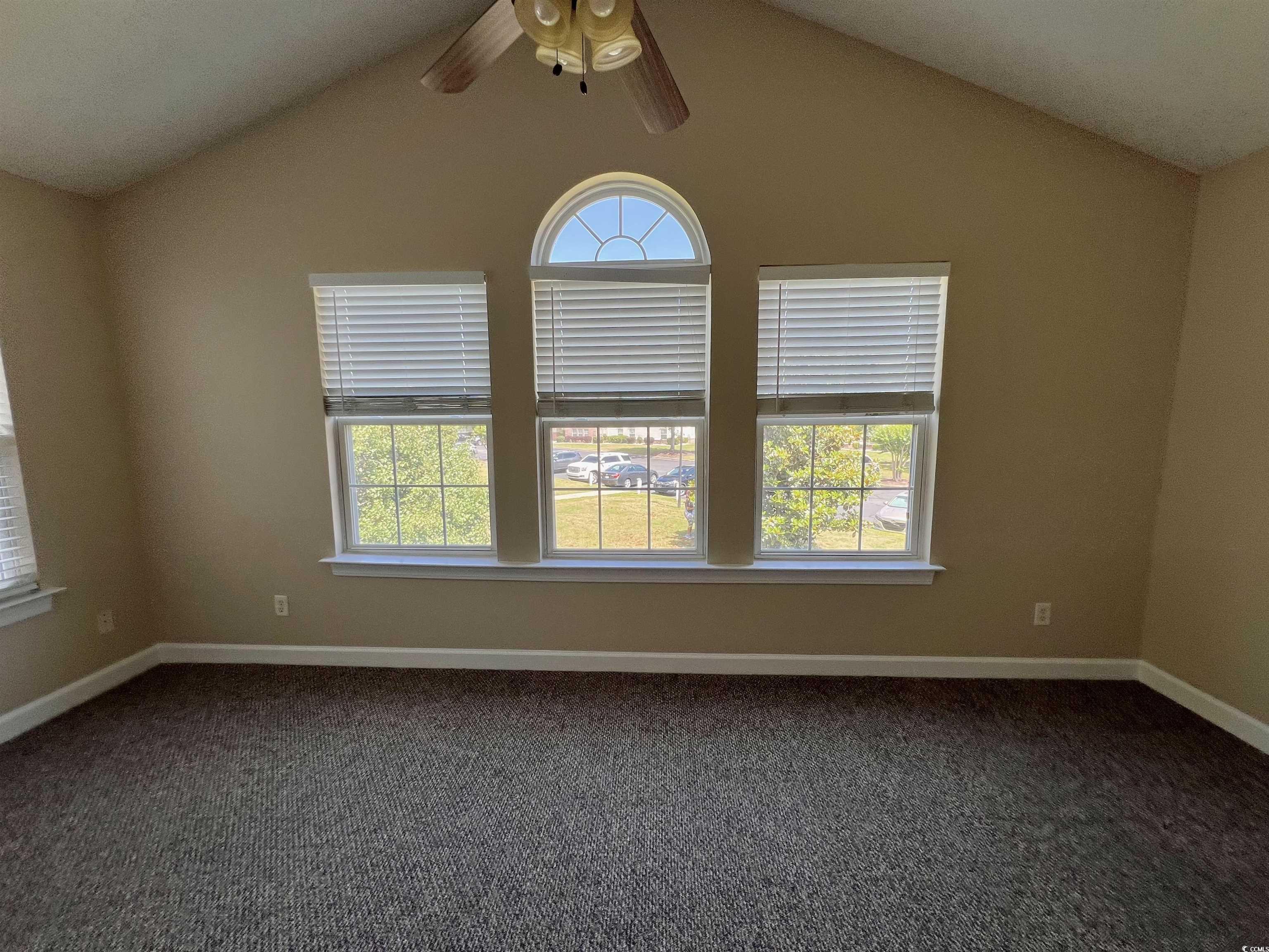 4394 Daphne Lane, Unit F Murrells Inlet, SC 29576 - Photo 12 of 40 Spare room featuring a ceiling fan, dark colored carpet, lofted ceiling, and baseboards