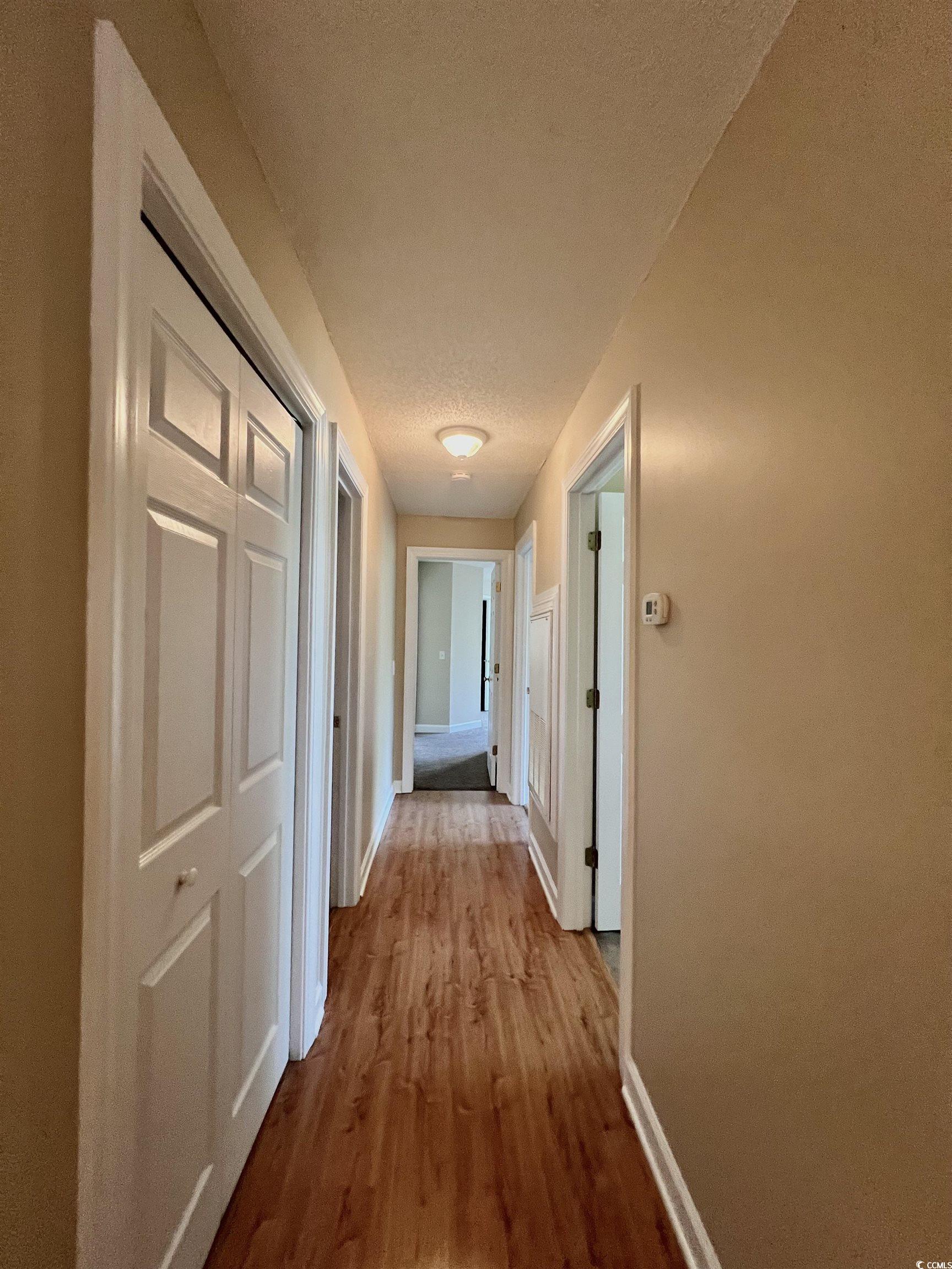 4394 Daphne Lane, Unit F Murrells Inlet, SC 29576 - Photo 16 of 40 Hall featuring baseboards, wood finished floors, and a textured ceiling